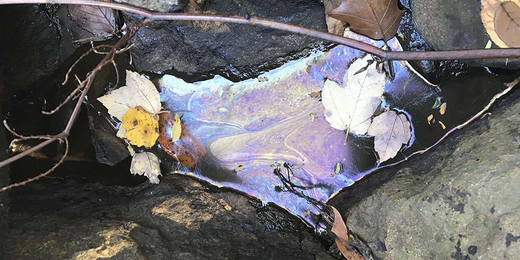 An oil sheen on water from a spill