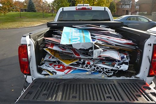 Signs piled into the back of a pick-up truck