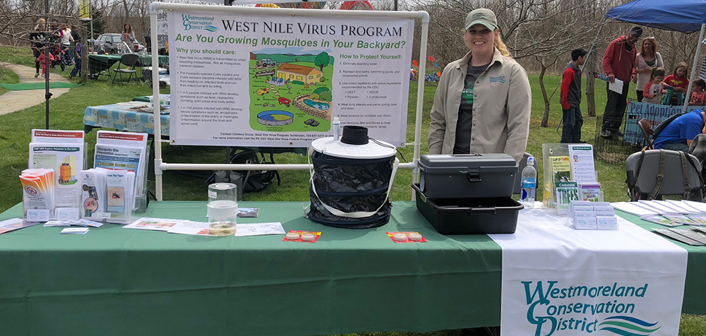 Conservation district staff share West Nile information at an outdoor event table