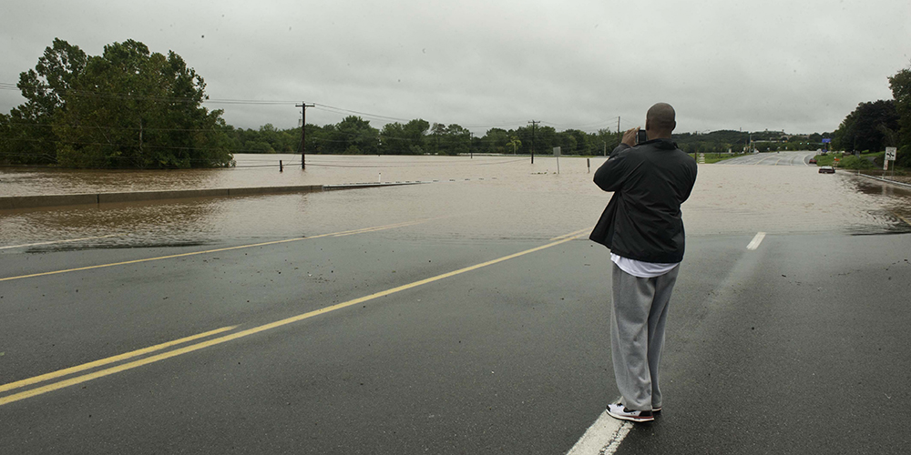 A man looks at a flooded roadway in Pennsylvania