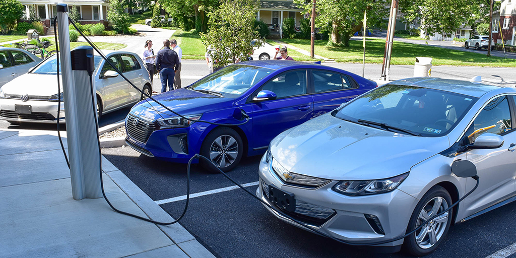 Electric vehicles charge up outside a shopping plaza