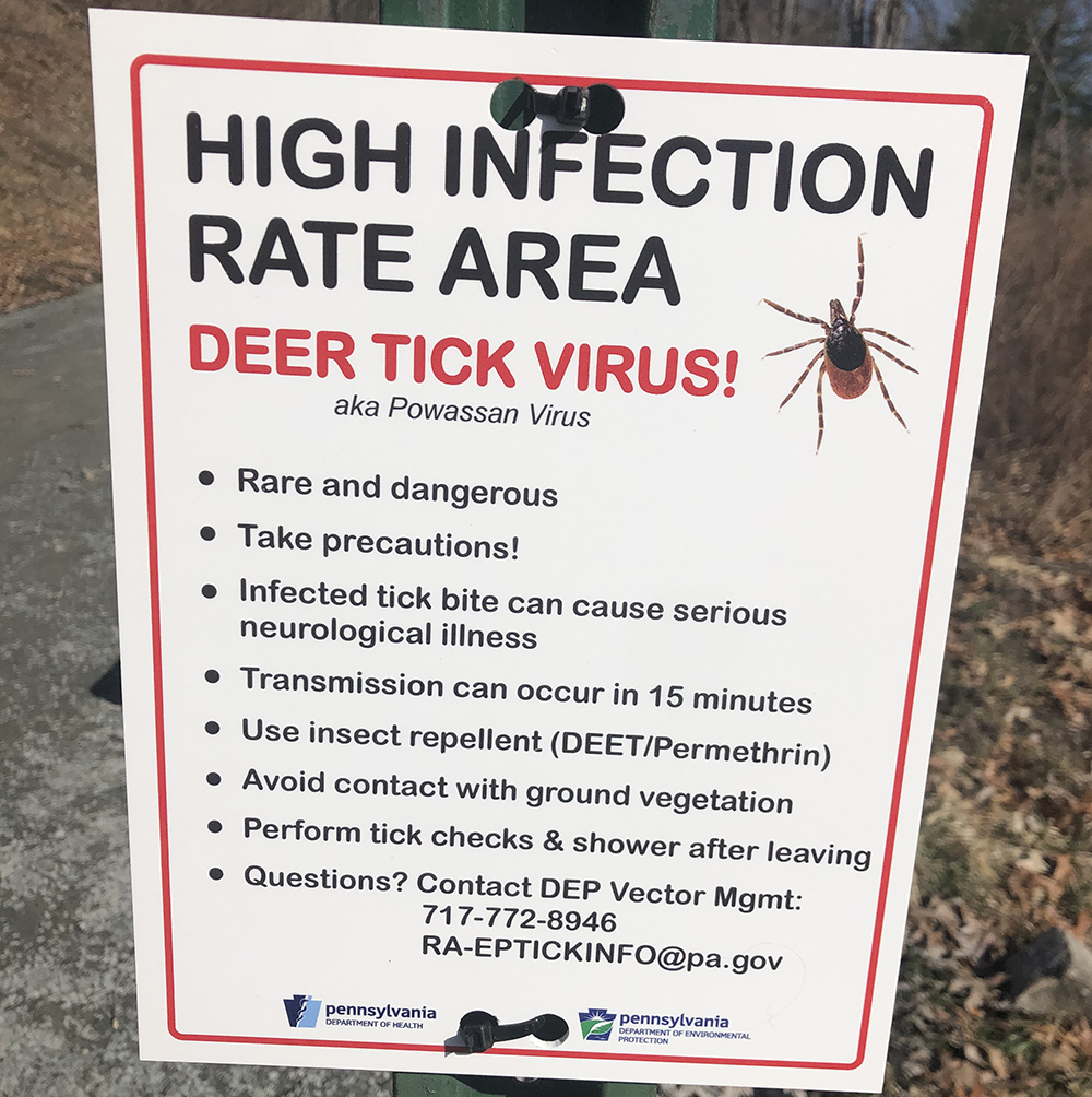 A sign warning of high tick infection rates is posted to a trailhead in Pennsylvania