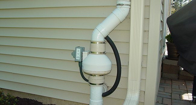 A radon mitigation system on the side of a house